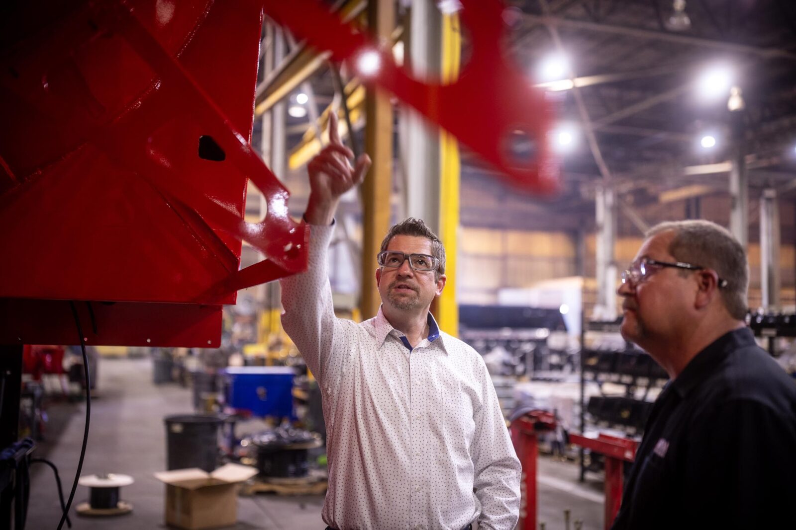 Two men looking at a trailer and pointing